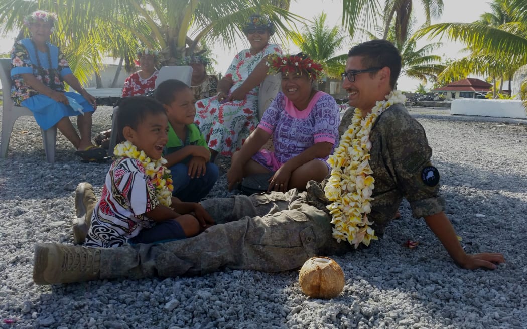 A New Zealand soldier spends time with locals on Penhryn.