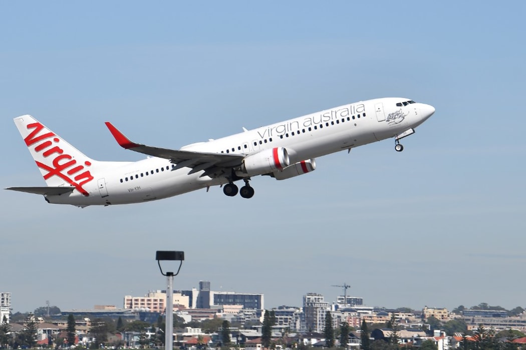 A Virgin Australia plane takes off at Sydney Airport in Sydney on March 19, 2020. -