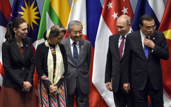 Prime Minister Jacinda Ardern, Myanmar State Counsellor Aung San Suu Kyi, Malaysia's Prime Minister Mahathir Mohamad, Russian President Vladimir Putin and Chinese Premier Li Keqiang arrive on stage to pose for a group photo with other leaders.