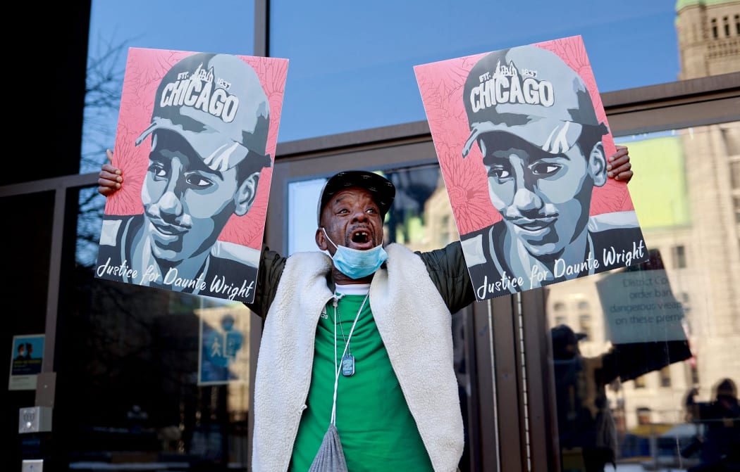 A demonstrator holds images of Daunte Wright outside the Hennepin County Government Center in Minneapolis, Minnesota, on 23 December.
