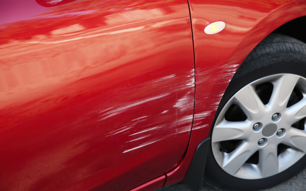 Modern red car with scratch outdoors, closeup