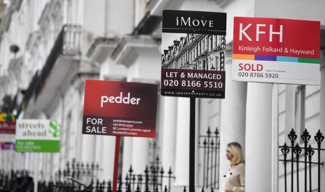 Estate Agents' "For Sale", "Sold", and " To-Let" boards are pictured outside residential properties in south London.