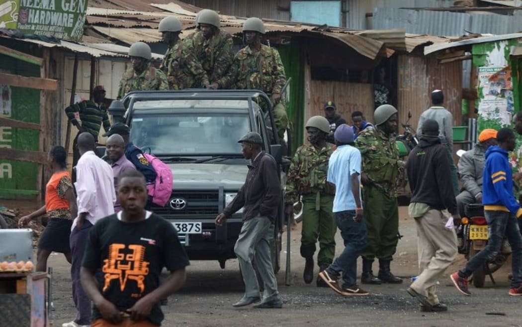 Kenyan riot police officers patrol a neighbourhood in Nairobi following riots.