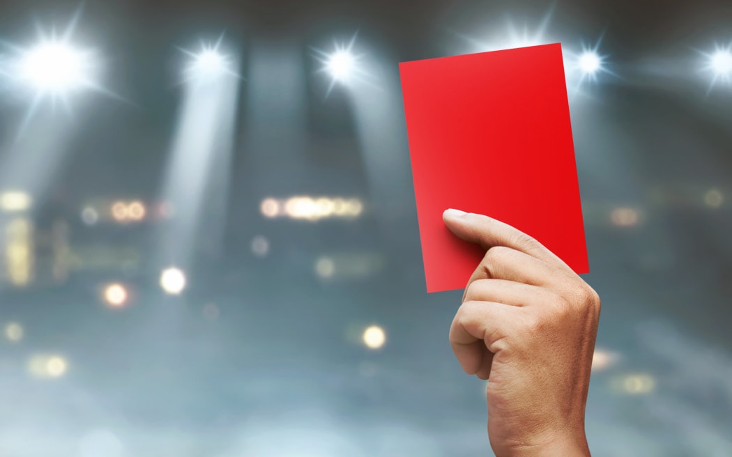 A red card is displayed in a sports stadium.