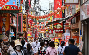 This photo taken on September 17, 2022 shows people walking down a street in the Chinatown section of Yokohama, Kanagawa prefecture, south of Tokyo. - Inflation in Japan hit 2.8 percent in August, the highest level since 2014, government data showed on September 20, 2022 as soaring energy prices bite. (Photo by Richard A. Brooks / AFP)