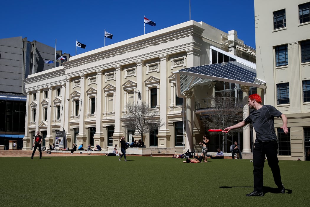 Wellingtonian's embracing a hot lunch break as the 5 flags up for debate fly high on top of Wellington's Town Hall.