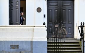 Rabbi Dovid Gutnick speaks to the media next to the burnt front entrance of the East Melbourne Synagogue in Melbourne on July 6, 2025. A man suspected of setting fire to an Australian synagogue as worshippers ate dinner inside has been arrested and charged, police said on July 6. (Photo by William WEST / AFP)