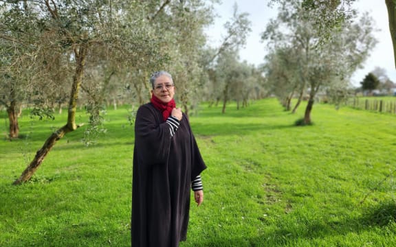 Huhana Smith standing in her olive grove