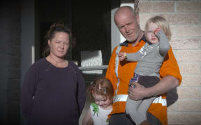 Jody Devine and her family outside their earthquake damaged home.