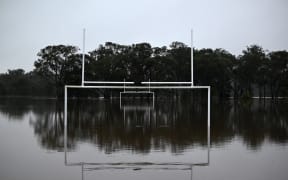 Water level rises inside Cliftleigh Meadows Park from the over flowing Wallis Creek in Gillieston Heights near New South Wales town of Maitland on May 23, 2025. Record floods cut a destructive path through eastern Australia on May 23, caking houses in silt, washing out roads and separating 50,000 people from help. (Photo by Saeed KHAN / AFP)