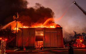 A Bank of America is fully engulfed in flames along Lake Ave. during the Eaton fire in the Altadena area of Los Angeles county, California on January 8, 2025. At least five people are now known to have died in wildfires raging around Los Angeles, with more deaths feared, law enforcement said January 8, as terrifying blazes leveled whole streets, torching cars and houses in minutes.
More than 1,000 buildings have burned in multiple wildfires that have erupted around America's second biggest city, forcing tens of thousands of people from their homes. (Photo by JOSH EDELSON / AFP)