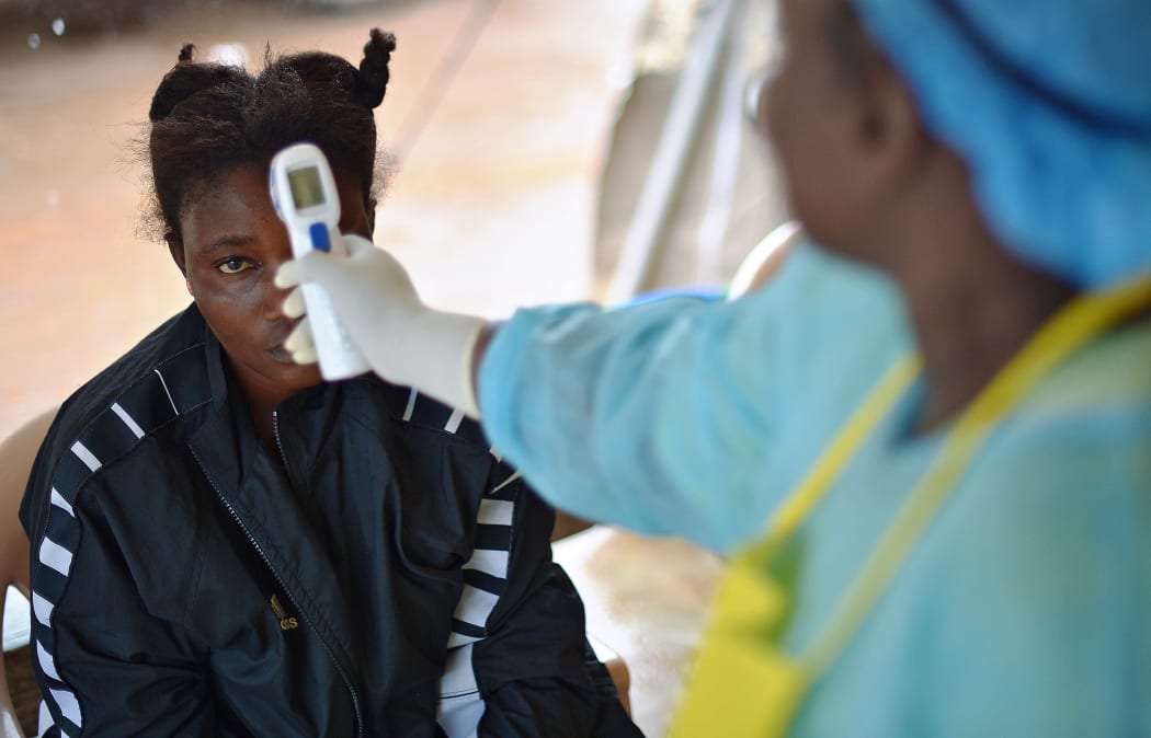 A girl is checked for the Ebola virus in a Sierra Leone clinic.