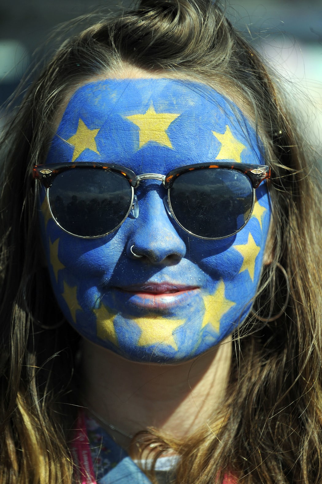 A festival-goer with a European flag painted on her face poses for a photograph on day three of the Glastonbury Festival.