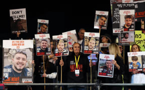 Relatives and supporters hold placards bearing portraits of Israeli hostages held in Gaza since the October 7 attacks by Hamas in southern Israel, during a rally calling for their release, in Tel Aviv on 30 December, 2023.