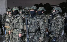 Soldiers try to enter the National Assembly building in Seoul on December 4 2024, after South Korea President Yoon Suk Yeol declared martial law. - South Korea's President Yoon Suk Yeol on December 3 declared martial law, accusing the opposition of being "anti-state forces" and saying he was acting to protect the country from "threats" posed by the North. (Photo by Jung Yeon-je / AFP)