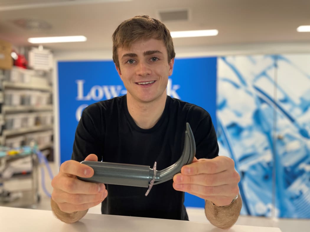 Student Engineer of the Year, Francis Pooke with his new tracheostomy kit device. The device is cylindical wiht a long curved horn-shaped dialator at one end.