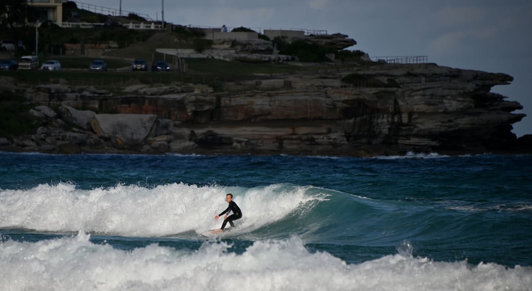 A surfer rides a wave at Bondi Beach.