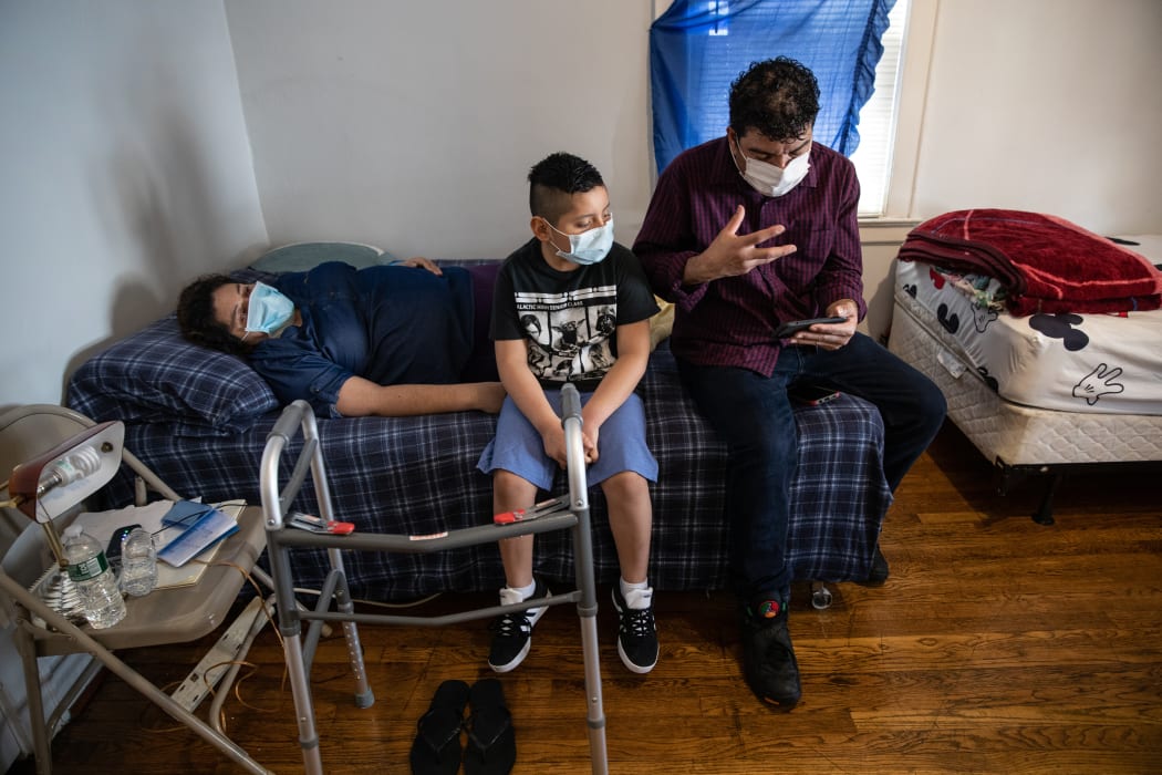 Connecticut residents Zully (left), Marvin (right), and Junior, 7, talk to a doctor via Zoom while recovering from COVID-19 at home.