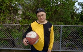 Jesse Coles-Hart holds his basketball securely under one arm.