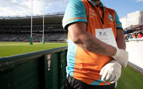 A security staff member wearing gloves during a Super Rugby match at Eden Park.