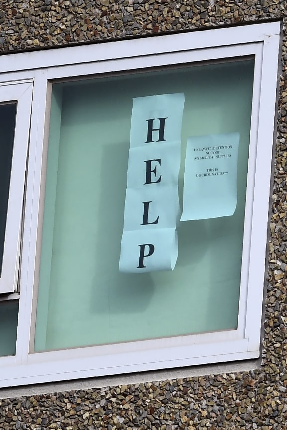 A sign is seen pasted on a window at one of nine public housing estates locked down due to a spike in COVID-19 coronavirus numbers in Melbourne on July 6, 2020.