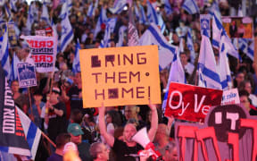 Israeli left-wing activists wave national flags and hold placards during an anti-government demonstration in Tel Aviv, on May 4, 2024, amid the ongoing conflict in the Gaza Strip between Israel and the Palestinian militant Hamas movement. (Photo by JACK GUEZ / AFP)