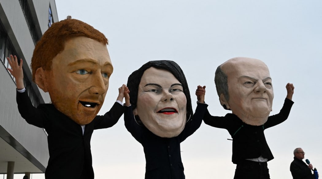 masks of (L-R) the leader of Germany's free democratic FDP party Christian Lindner, the co-leader of Germany's Greens (Die Gruenen) Annalena Baerbock and German Finance Minister, Vice-Chancellor and the Social Democratic SPD Party's candidate for chancellor Olaf Scholz