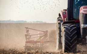 The tractor harvester working on the field