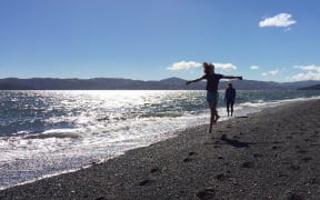 Beach-goers enjoy the sunshine at Eastbourne in Wellington.