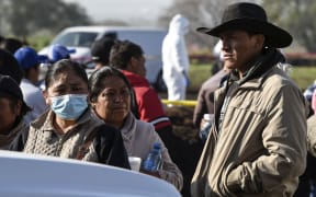Relatives of victims wait at the scene of a massive blaze trigerred by a leaky pipeline in Tlahuelilpan.