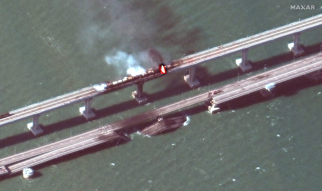 A Maxar Technologies satellite image taken and released on 8 October 2022 shows smoke billowing from a fire on the Kerch Bridge that links Crimea and Russia, after a truck exploded.