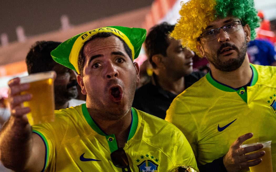 Brazil supporters drink beer as they attend the FIFA Fan Festival at Al Bidda park in Doha on 20 November, 2022, on the opening of the Qatar 2022 World Cup football tournament.