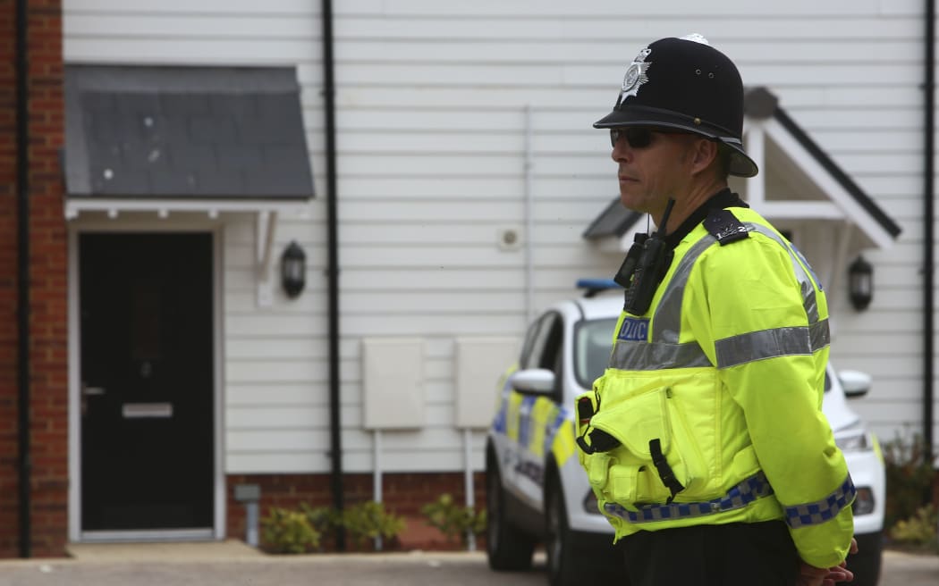 A police officer stands guard outside a residential address in Amesbury, a man and woman were found unconscious.