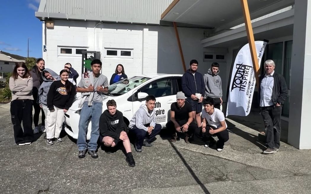 Young people by and around a charity car with signage on the door of charity Youth Inspire