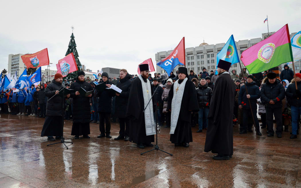Mourners gather with priests to lay flowers in memory of more than 60 Russian soldiers that Russia says were killed in a Ukrainian strike on Russian-controlled territory, in Samara, on January 3, 2023.