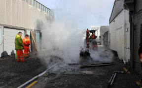 A digger clears the area around the bore, after water has been pumped down it.