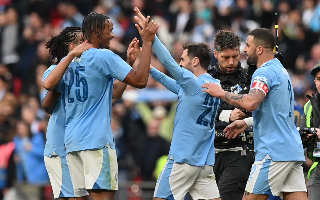 Manchester City's Portuguese midfielder #20 Bernardo Silva (centre right) celebrates with teammates on the pitch after the English FA Cup semi-final football match between Manchester City and Chelsea at Wembley Stadium in north west London on April 20, 2024. Manchester City won the game 1-0. (Photo by Glyn KIRK / AFP) / NOT FOR MARKETING OR ADVERTISING USE / RESTRICTED TO EDITORIAL USE