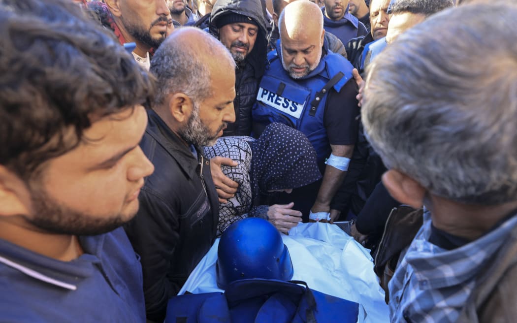Colleagues and family members mourn over the body of Al Jazeera cameraman Samer Abu Daqa, who was killed during Israeli bombardment, during his funeral in Khan Yunis on the southern Gaza Strip on 16 December, 2023.