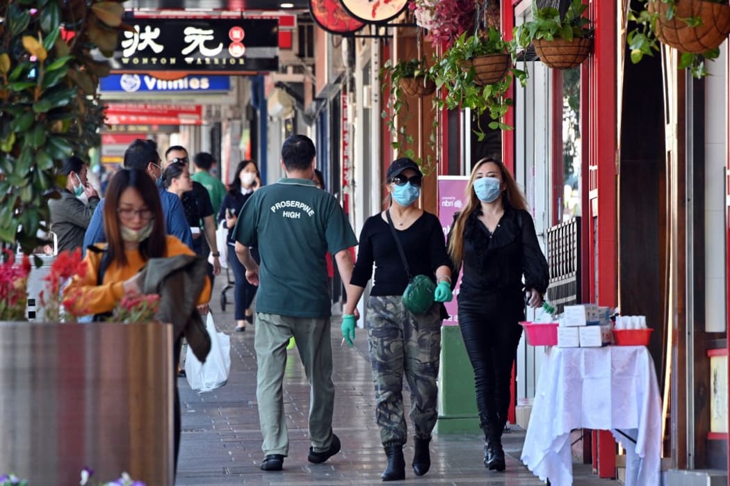 People wearing face masks walk in the Burwood suburb of Sydney on April 14, 2020, amid the COVID-19 coronavirus pandemic.