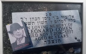 A copy David Cohen's book the Book of Cohen sits atop Leonard Cohen's gravestone in Montreal