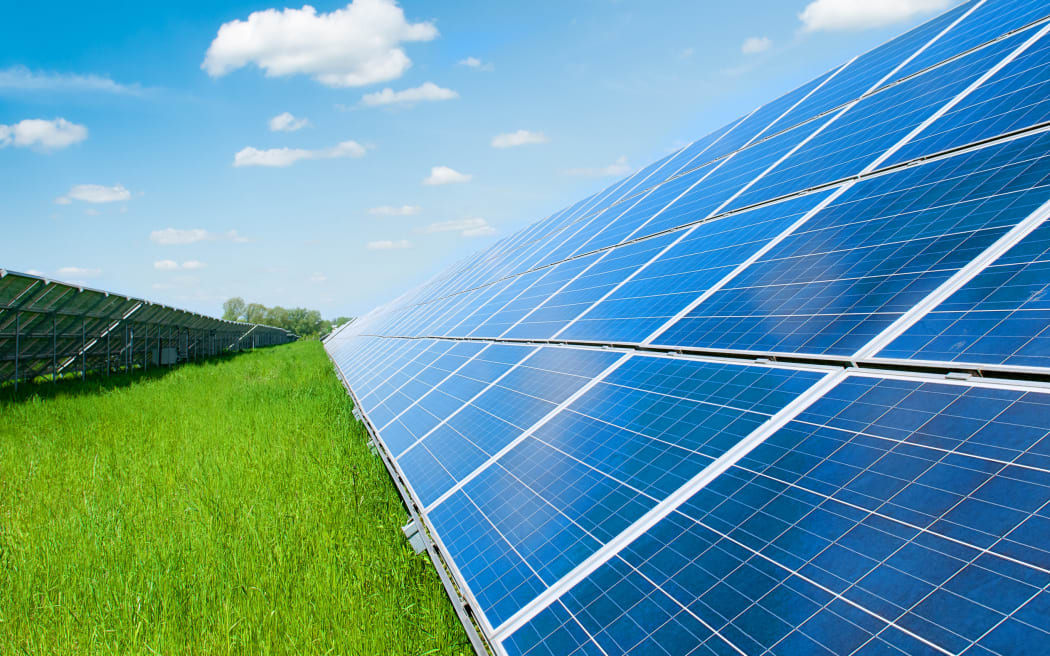 Solar panels, grass and and blue sky.