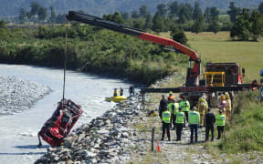 The car which crashed into the Wanganui River on the West Coast is removed from the water.