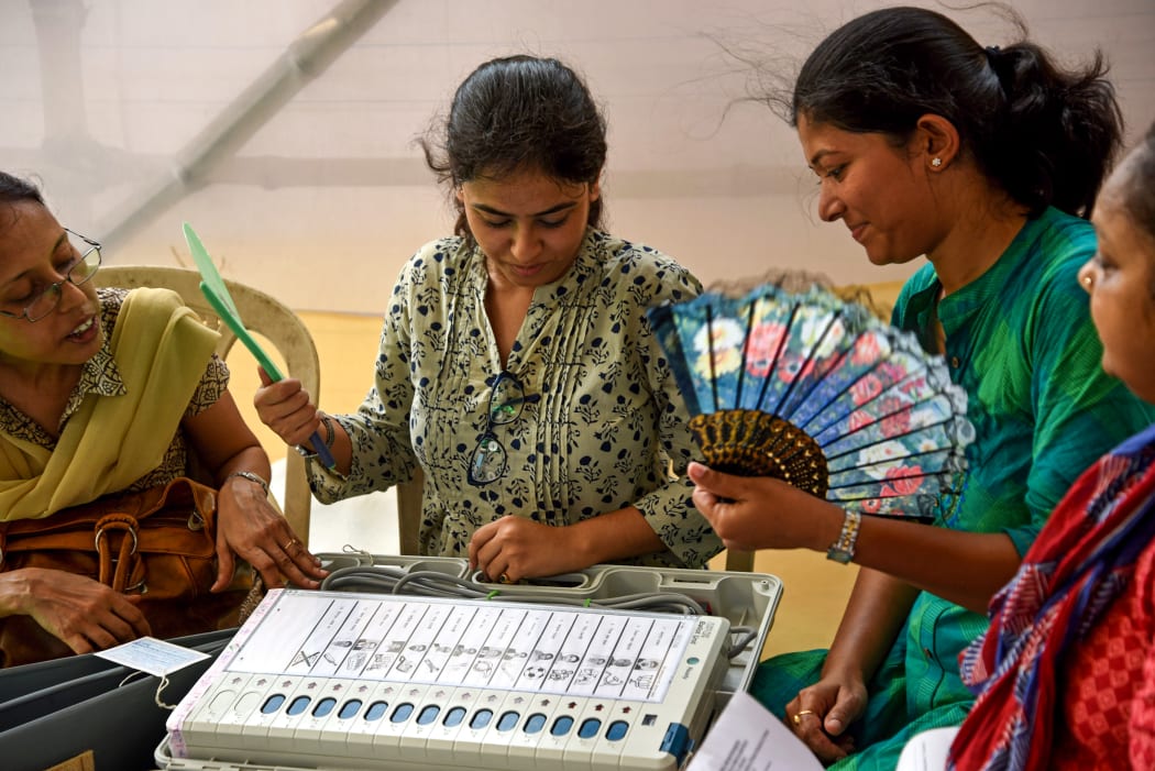 Indian polling officials check an Electronic Voting Machine (EVM) at a distribution centre in Kolkata on May 18, 2019, on the eve of the 7th phase of India's general election. (Photo by STR / AFP)