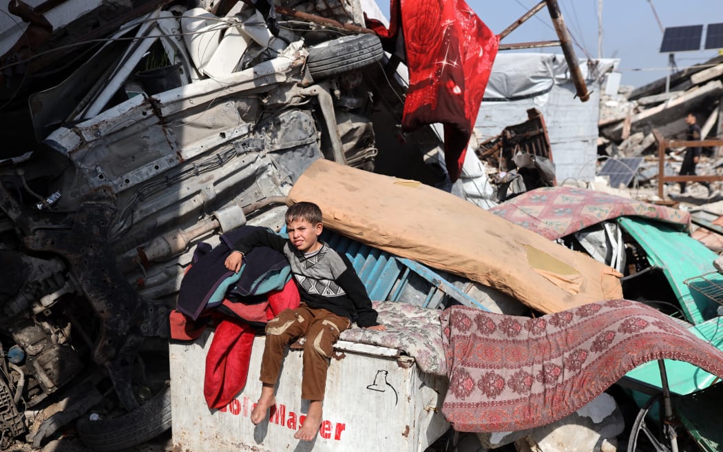 A displaced Palestinian child sits outside his family's tent in the Jabalia refugee camp in the north of the Gaza Strip on January 6, 2026.