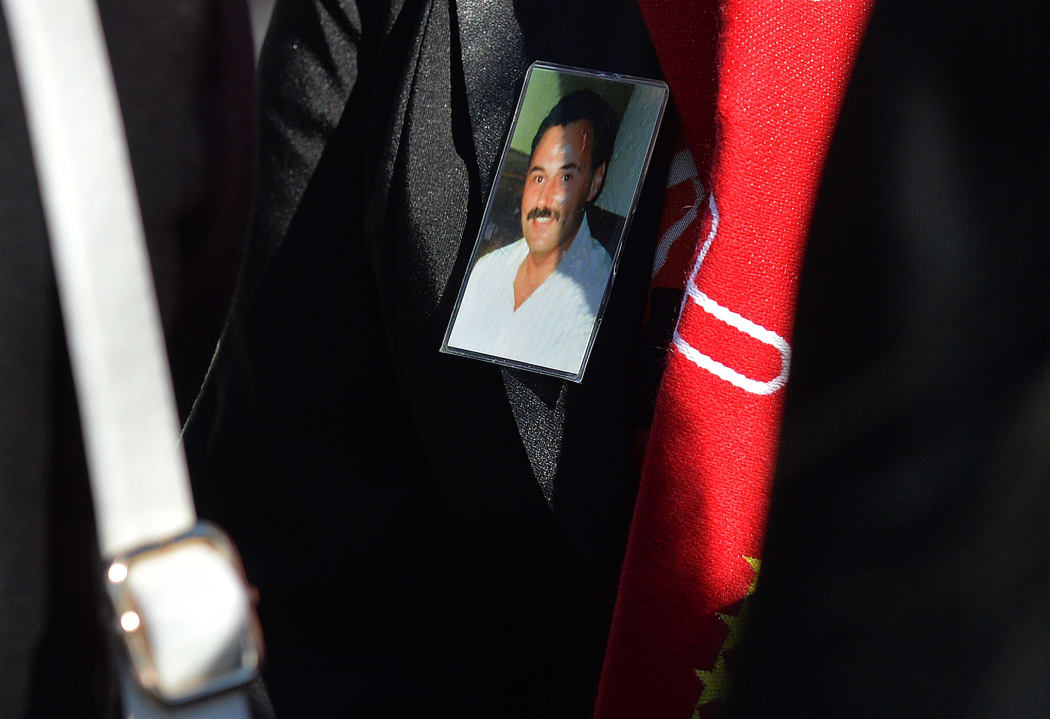 People hold images of Hillsborough disaster victims as they queue to enter the inquest into the disaster.