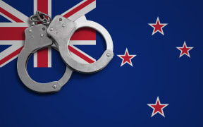 New Zealand flag  and police handcuffs. The concept of crime and offenses in the country.