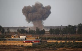 In the Israeli-annexed Golan Heights, smoke rises above buildings across the border in Syria during air strikes.