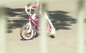A child on a bike at an emergency accommodation motel.