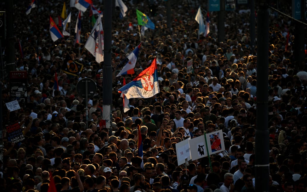 People wave Serbian national flags as tens of thousands of protesters gather in central Belgrade as they issue an "ultimatum" to the populist government to call early elections after months of student-led strikes across the country, in Belgrade, on June 28, 2025. Anti-graft protests have rocked the Balkan nation since November when 16 people were killed in the northern city of Novi Sad by a train station roof collapse, a tragedy widely blamed on entrenched corruption. For over half a year, students have blockaded universities and organised large demonstrations around the country, demanding a transparent investigation into the tragedy with their focus shifting after little action from authorities to call for early parliamentary elections. (Photo by OLIVER BUNIC / AFP)