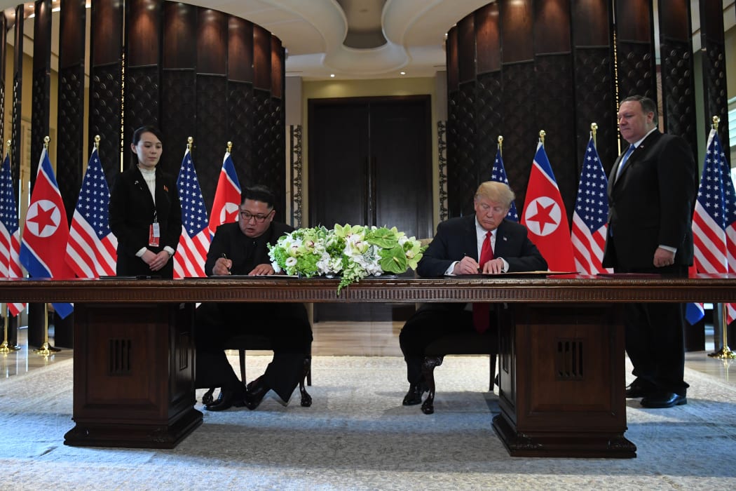 US President Donald Trump and North Korea's leader Kim Jong-un sign documents after the summit meeting.